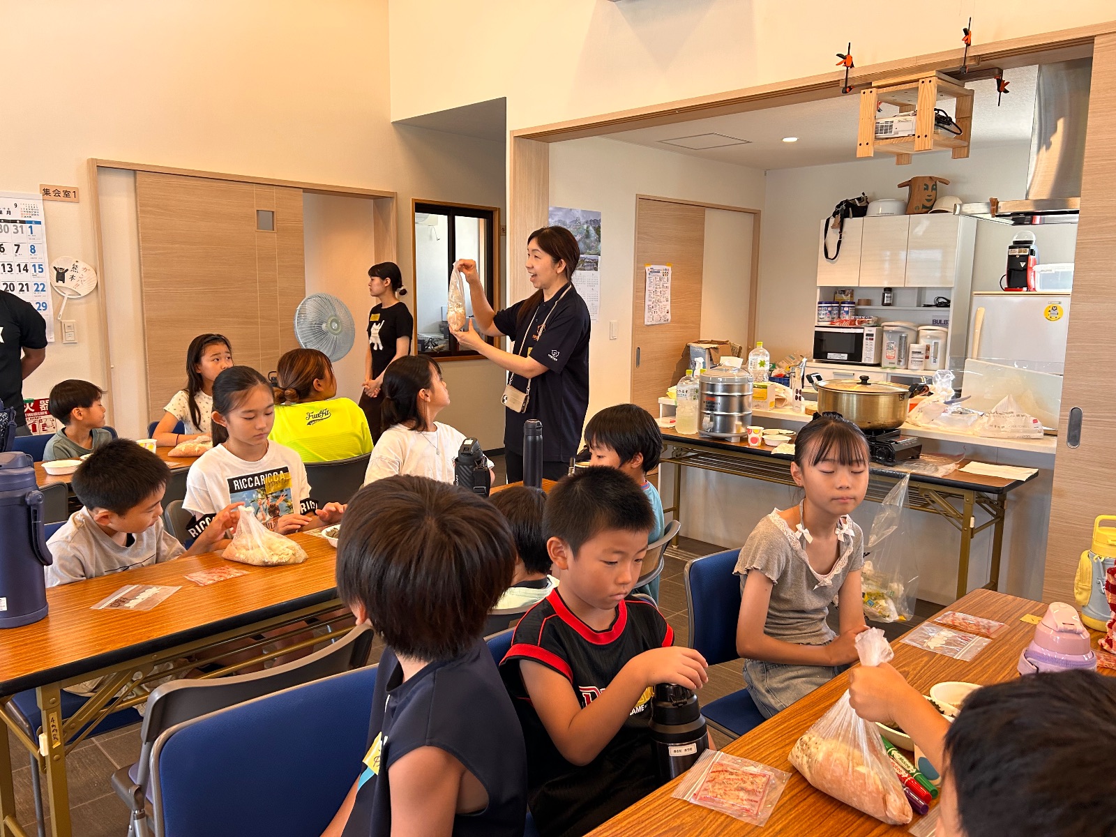 防災調理について説明を聞く子どもたち