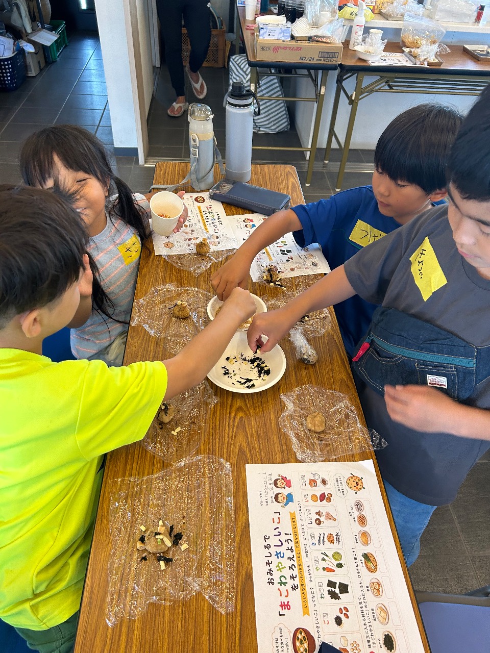 昼食づくりを支えるスタッフと子どもたち