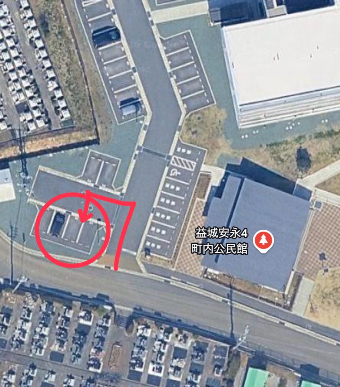 安永4町内公民館の送迎車指定駐車位置。公民館の西側にある駐車区画を赤丸と矢印で表示